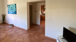 A spacious living area with a tiled floor, a flat-screen TV, and a painting of a rose on the wall. - Chalet Villa Antonia (Ayamonte)