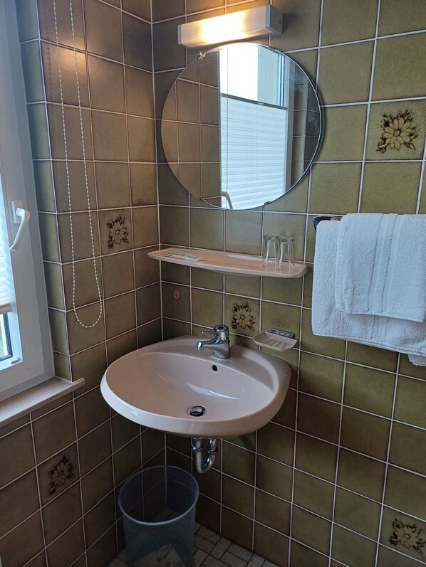 A bathroom with a sink, mirror, and towel rack. - Landgasthof Adler (Illmensee)
