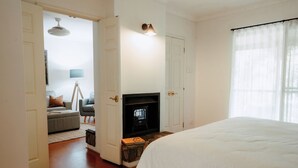 Une chambre d’hôtel avec un lit, une cheminée, un canapé et une télévision.