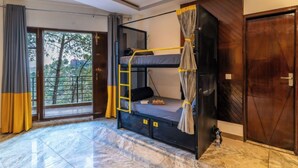 A room with a bunk bed, a ladder, a chessboard, and a view through large windows. - The Hosteller Kasauli (Kasauli)