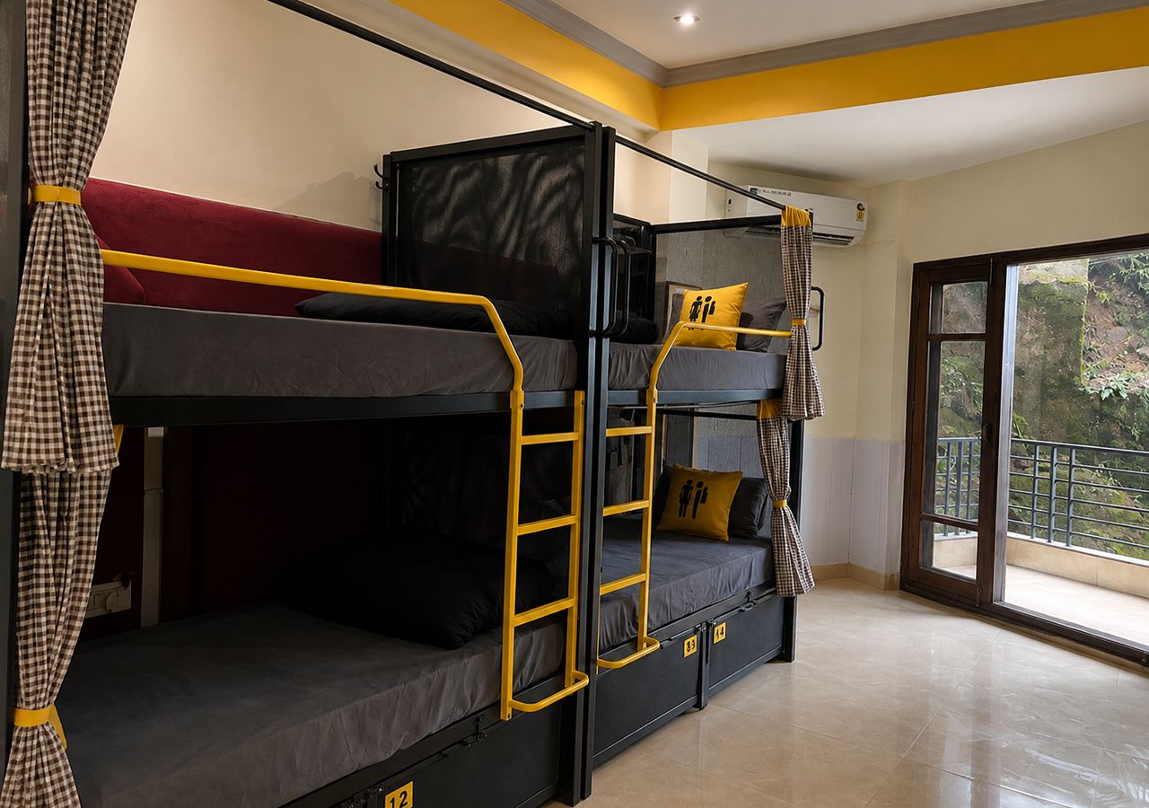 Habitación con literas, una escalera, ventana y balcón.