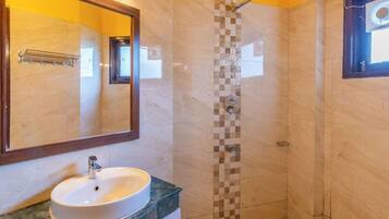 Un baño con lavamanos, espejo y ducha.