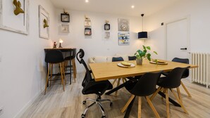 Un comedor moderno con una mesa de madera, sillas negras y una planta en maceta.