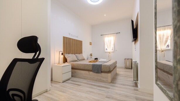 A modern bedroom with a bed, bedside tables, a TV, and a mirror. - Rome: room with comfort and shared areas Gran Via-Madrid (Madrid)