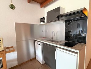Eine kleine Küche mit Mikrowelle, Spüle, Geschirrspüler und Herd.