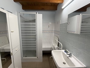 Ein Badezimmer mit Dusche, Waschbecken und Spiegel.