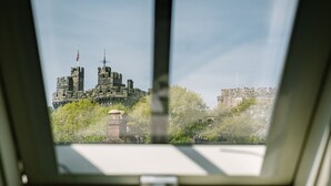 A view through a window of a historic building with intricate architecture, including towers and a flag. - Domain Boutique Rooms (Lancaster)