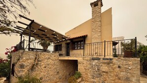 A stone house with a balcony, stone walls, and potted plants. - Electra Stone Suite  (Roumeli)