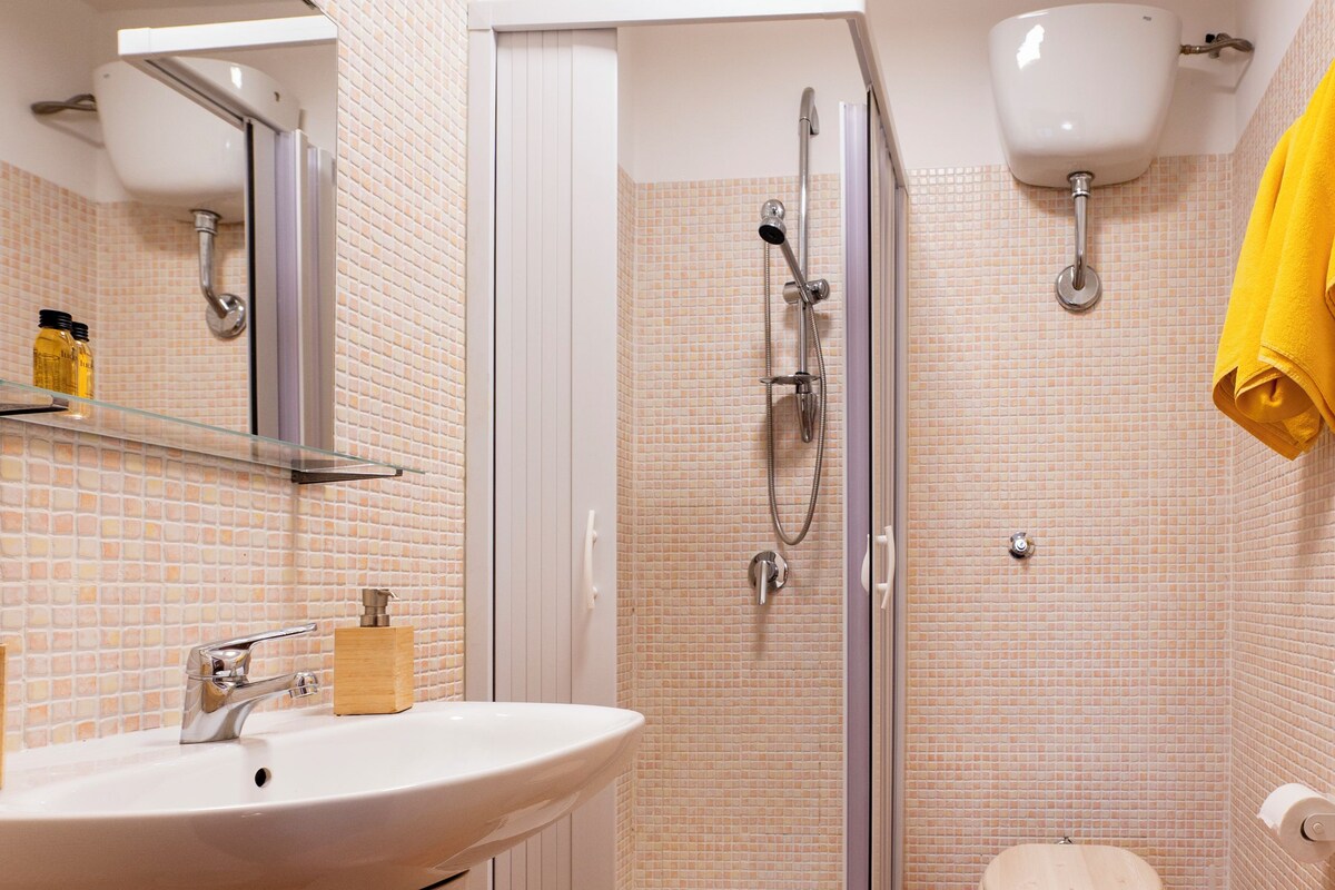 A bathroom with a shower, toilet, and sink.