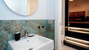 A bathroom with a white sink, a round mirror, and a blue and white textured wall. - SECRET SUITE VARIGOTTI (Varigotti)