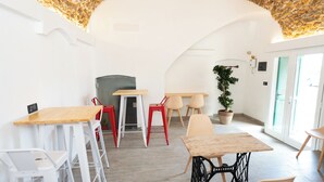 A dining area with a stone ceiling, white walls, and a potted plant. - SECRET SUITE VARIGOTTI (Varigotti)