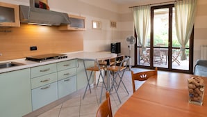 Une cuisine compacte équipée d’une cuisinière, d’un évier et d’un coin repas avec une table et des chaises.