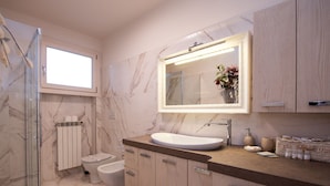 Een badkamer met een marmeren wand, een grote spiegel, een wastafel, toilet en douche.