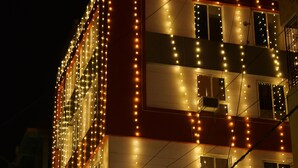 A hotel building with a sign reading "Hotel Paradise Premier" and multiple windows adorned with string lights. - Hotel Paradise Premier (Danapur)
