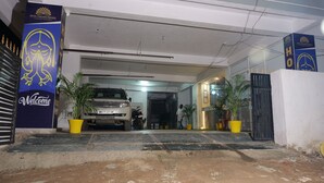 A hotel entrance with a parked SUV, a 'Welcome' sign, and potted plants. - Hotel Paradise Premier (Danapur)