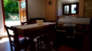 A dining area with a table, chairs, and a window overlooking a garden. - Pezzelelle (Roccamorice)