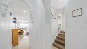 A modern interior with a staircase, white walls, and a wooden door. - Gallery on Kent | Prime Location (Newtown)