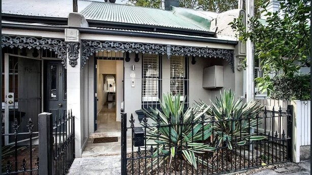 A residential house with a front entrance, a mailbox, and a large plant in the front yard. - Gallery on Kent | Prime Location (Newtown)