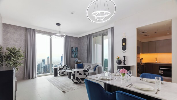 Un salon moderne avec un coin repas, de grandes fenêtres et une vue sur la ville.