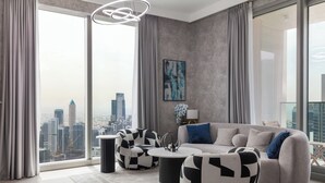 Un salon moderne avec vue sur la ville, comprenant un canapé, deux fauteuils à motifs et une table basse.