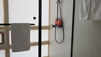 Ein Badezimmer mit Dusche, Handtuchhalter und Fenster.