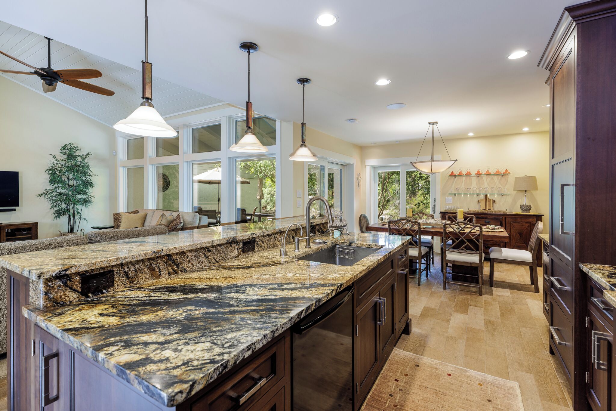 A spacious kitchen with granite countertops, a large island, and a dining area with a table and chairs.