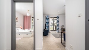 Quarto moderno com cama, mesa de cabeceira e vista para o exterior.