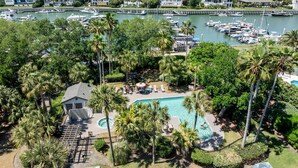 A marina with boats, a swimming pool surrounded by palm trees, and houses in the background. - Great Beach Condo in Quiet Section of Wild Dunes Resort! *301 Yacht Harbor* (Isle Of Palms)