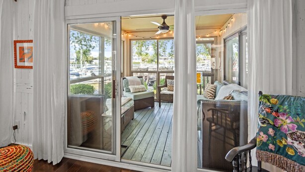 A covered outdoor seating area with wicker furniture and a colorful chair. - Great Beach Condo in Quiet Section of Wild Dunes Resort! *301 Yacht Harbor* (Isle Of Palms)