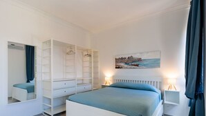A bedroom with a bed, a wardrobe, a painting, and two bedside lamps. - Cosy apartment for 6 guests with WIFI, A/C, TV, balcony and pets allowed (Sanremo)