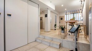 A modern hotel lobby with a reception desk, a seating area with plants, and a staircase leading to other rooms. - B48 Athens Dafni (Dafni-Ymittos)
