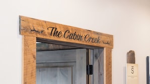 Ein Holzschild über einer Tür mit dem Schriftzug "The Cabin Creek".