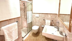 A bathroom with a glass-enclosed shower, a toilet, and a sink with a mirror. - LE RESIDENZE ACQUA DI MARE (Eden Beach)