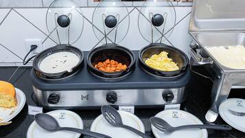 A buffet setup with three food stations labeled "CANJICA," "MOLHO DE LEICHA," and "OVOS MEXIDOS."