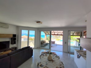 A living room with a sofa, TV, and a dining area with a table and chairs. - VILLA BEAUTIFUL VIEW - HEATED POOL (Alcamo Marina)
