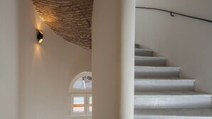 Una escalera con escalones blancos y un muro de ladrillo.