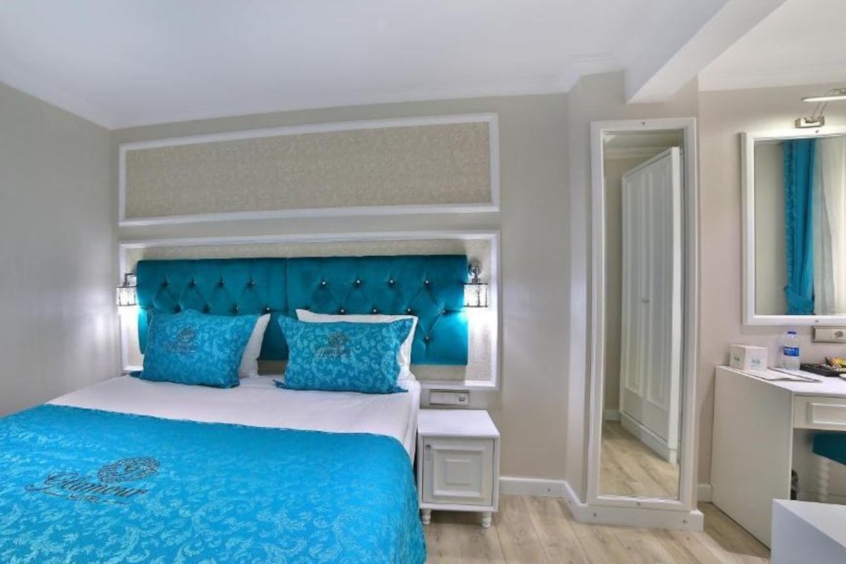 Un dormitorio con una cama grande, una mesita de noche, un aparador y un espejo.