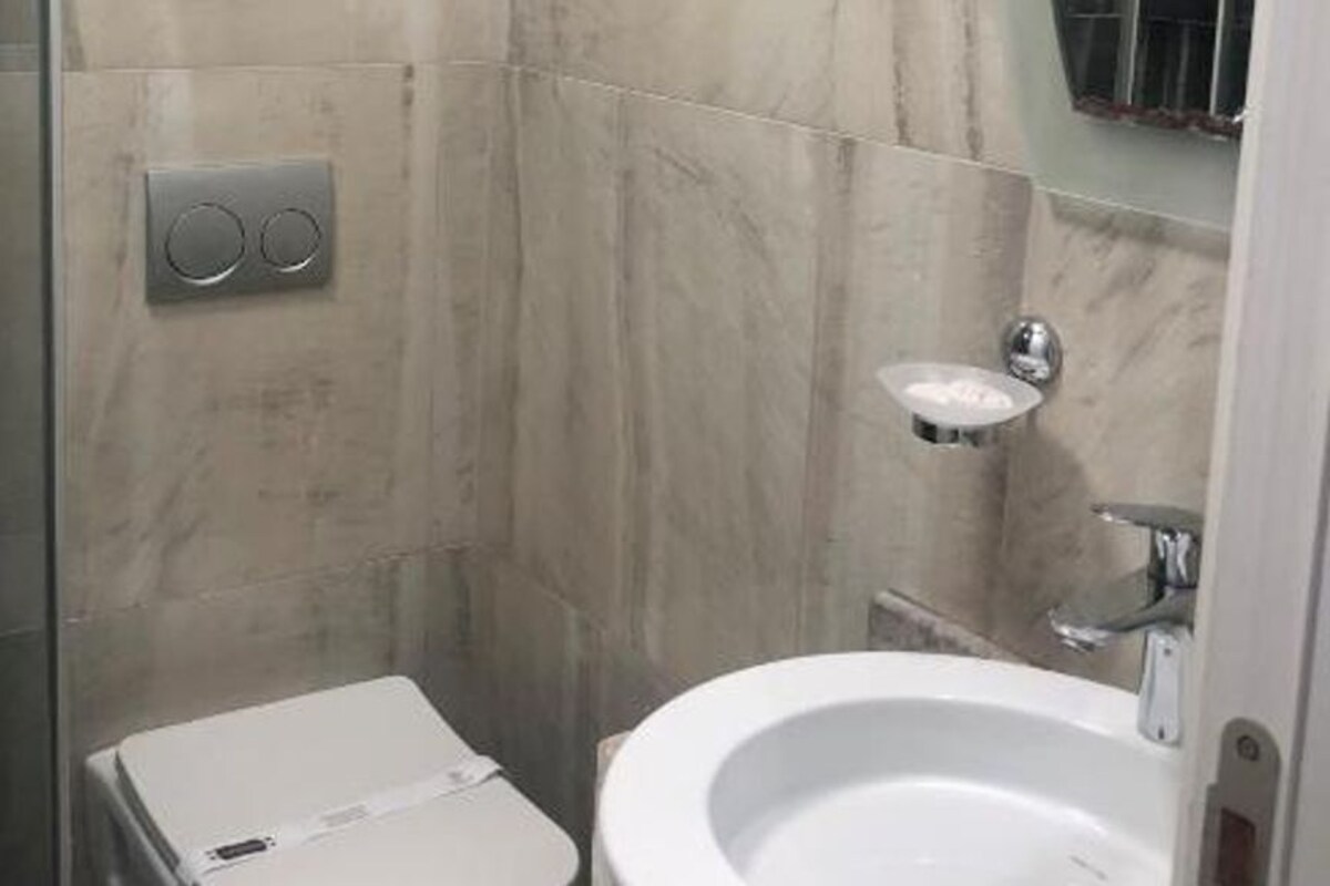 Une petite salle de bain comprenant des toilettes, un lavabo et un espace douche.