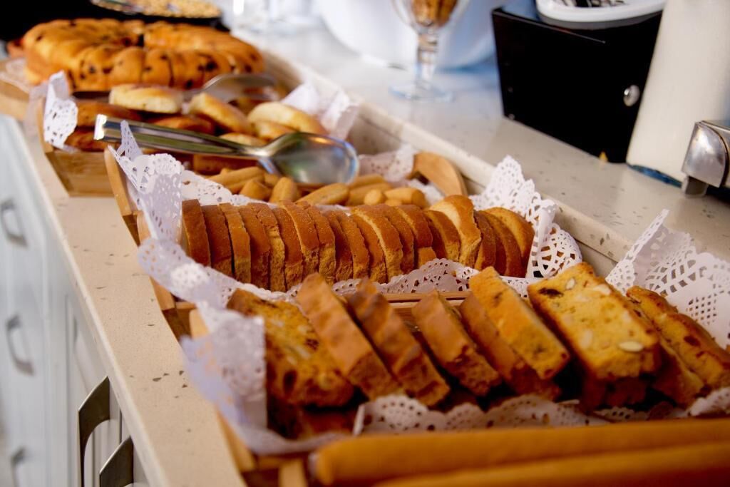 A buffet table with various breads and pastries.