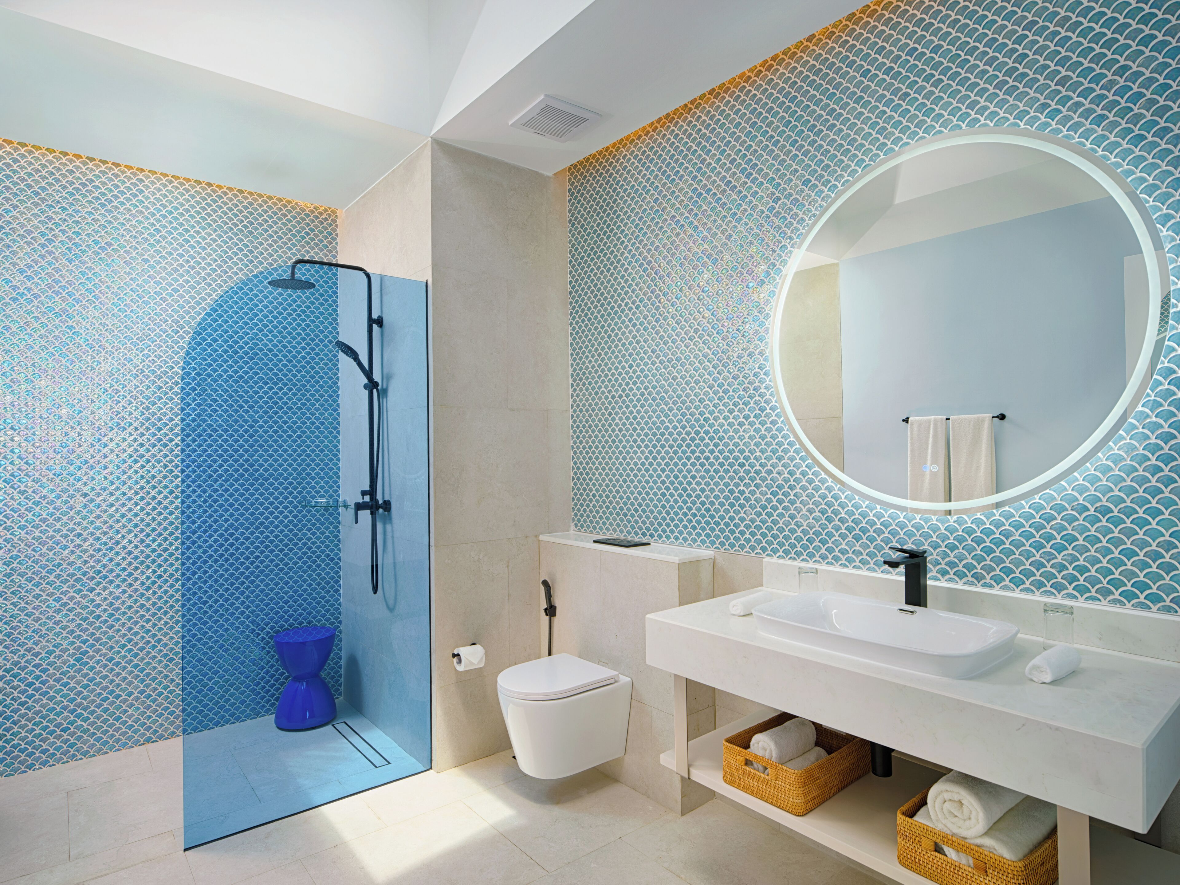 A modern bathroom with a glass shower enclosure, a white sink, and a large mirror.