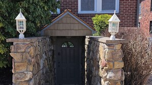 A house with a stone entrance, a brick facade, and two white lanterns on the pillars. - Shoreline Estates - Glamping B (Confluence)