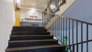 Eine Treppe mit Metallgeländer führt zu einem Raum, der mit „HOTEL GRAND SHIVAY“ beschriftet ist.