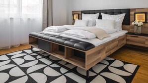 Une chambre à coucher moderne avec un lit, des tables de chevet et un tapis à motifs.