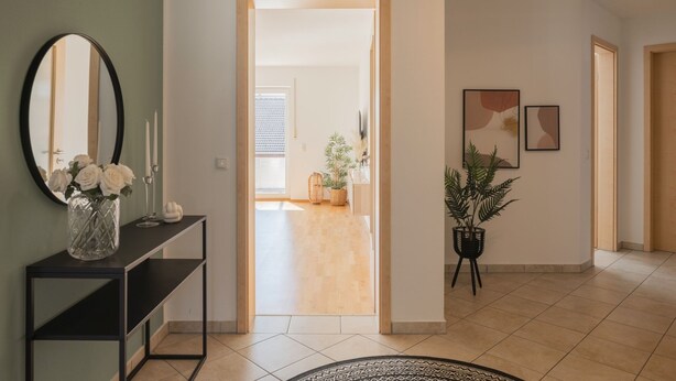 Un intérieur moderne avec une console, un miroir et une plante en pot.