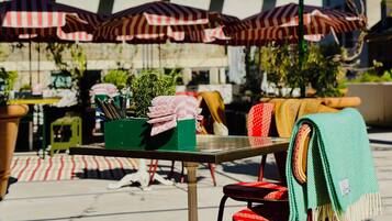 An outdoor seating area with tables, chairs, and umbrellas.
