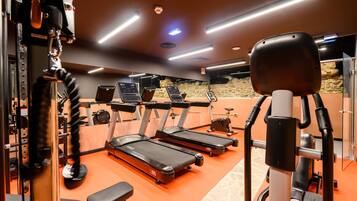 A gym with treadmills, exercise bikes, and weight machines.