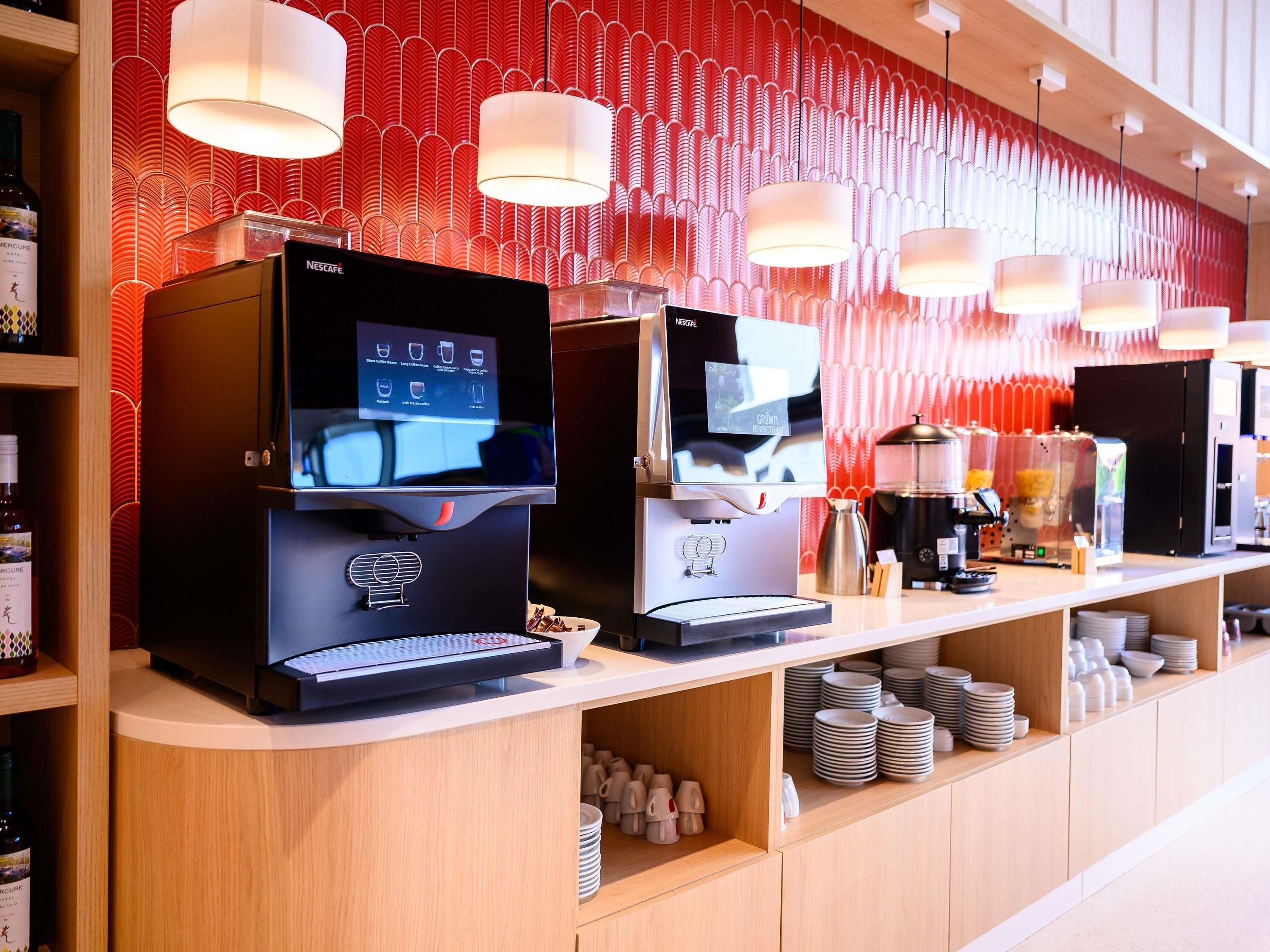 Eine moderne Kaffeestation mit Espressomaschinen und einem digitalen Menü.