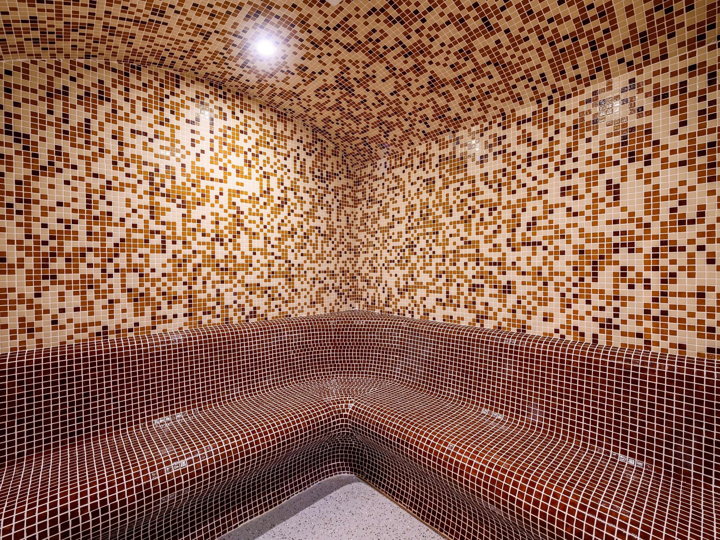 A room with a unique mosaic tile design on the walls and floor, creating a patterned appearance.