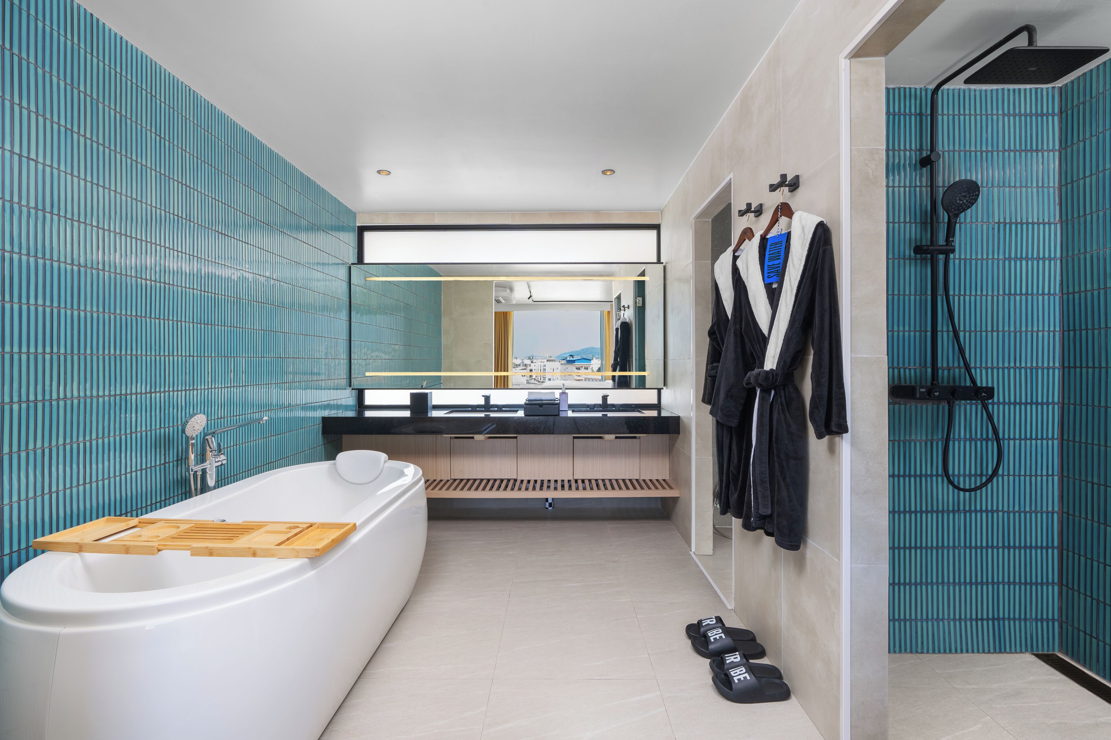 Une salle de bain moderne avec une baignoire, une douche et un grand miroir.