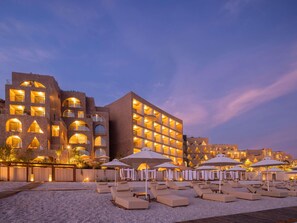 A hotel with multiple balconies, outdoor seating, and a pebble beach. - Green Coast Hotel Mgallery Collection (Himare)